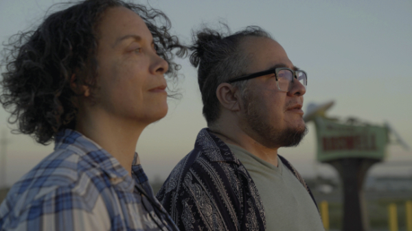 Characters Miguel and Elise look to the horizon on their way to film and interview Miguel’s family. Production still from Road to Roswell – A Welcome to
Roswell Short, 2023. Courtesy of StormMiguel Florez.