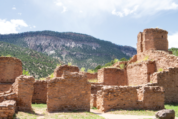photograph of jemez historic site - limestone and sandstone walls in front of cliff faces in background