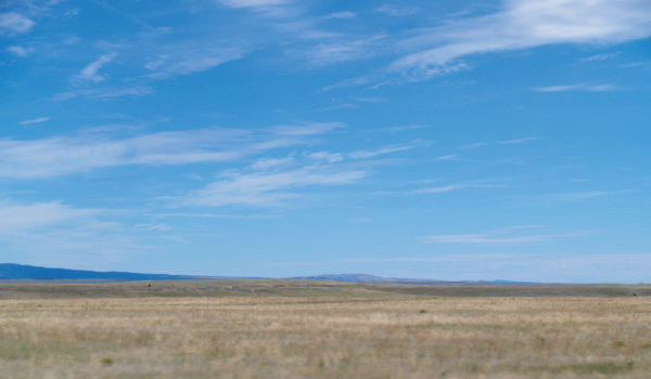 Figure 6: Great plains near Las Vegas, New Mexico: Beneath the extensive grasslands are flat-lying old terrestrial and marine rocks that contain resources such as water, and in some places, oil and gas. In the distance are the southernmost Rocky Mountains. Photograph by Jayne C. Aubele, New Mexico Museum of Natural History and Science.