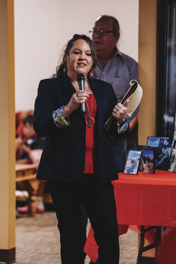 Woman with microphone holding legal pad