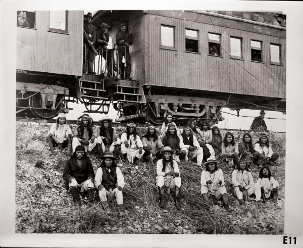 Archival photograph of prisoners outside a train car in 1886 Arizona