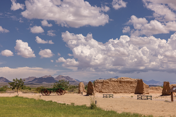 The northwest corner of the Fort Selden barracks facing southeast. A historic freight wagon can be seen to the left of the barrack ruins. Photograph by Tira Howard.