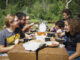 Diverse group of older children eating outdoors at a picnic table