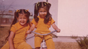 color photo of two girls on tricycles in matching yellow outfits in the mid 70s