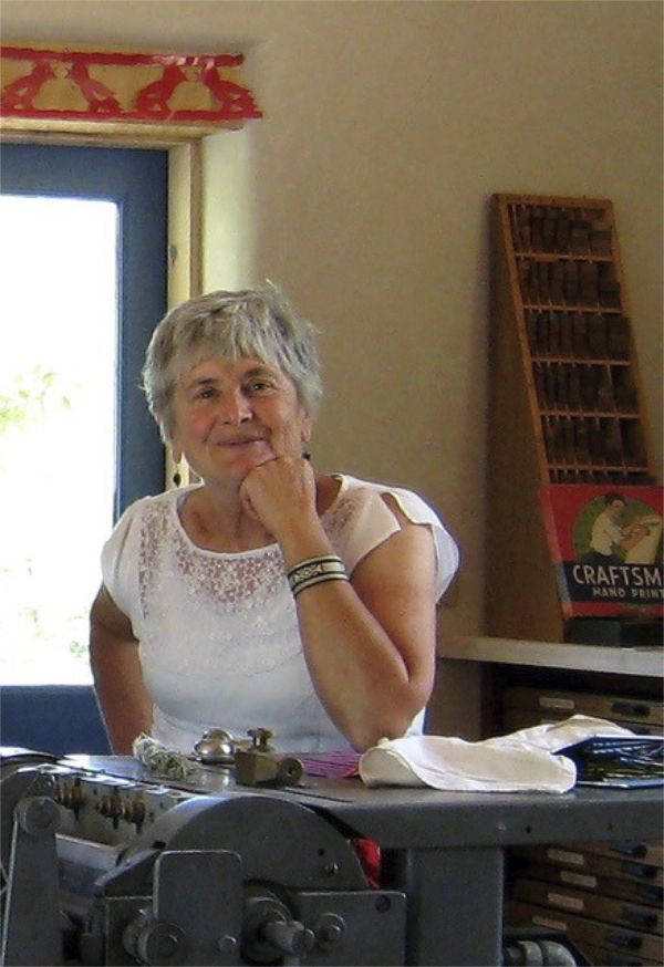 Color photograph of a woman with her fist propping up her chin