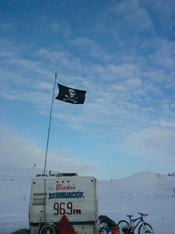 photograph of a pirate flag on a camper with a blake's whataburger sign and 96.9 fm painted on it