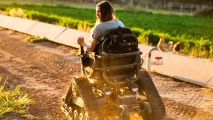 Woman navigating the rough terrain of her farm in an adapted wheelchair