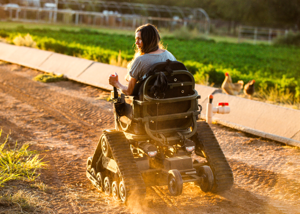 Woman navigating the rough terrain of her farm in an adapted wheelchair