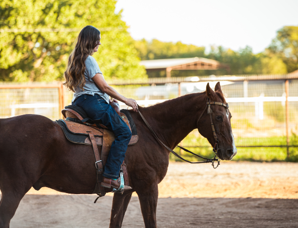 a woman riding a horse outdoors