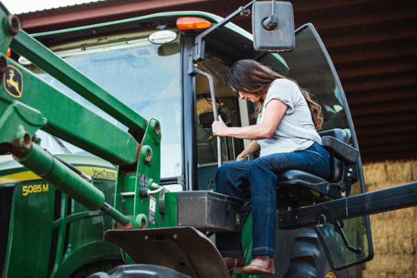 Tiffany Sánchez uses the Life Essentials Lift to get into her tractor, 2024. Photo by Anna Lisa Padilla.