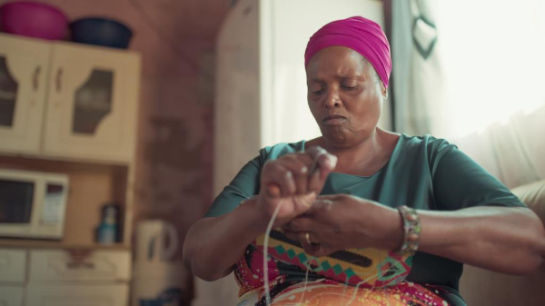 Weaving artist at home demonstrating her technique