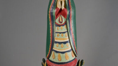 Hand-carved and painted wooden statue of a woman in a halo with rays, hands clasped in prayer, standing on a colorful pedestal with floral accents. [gen-ai]