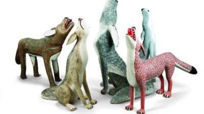 Six stylized sculptures of howling wolves in various colors and patterns are arranged together on a white background. [gen-ai]