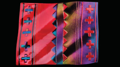 Rectangular glass artwork with a red and purple color scheme, featuring cross shapes and geometric patterns on a black background. [gen-ai]