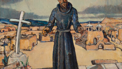 A statue of a friar stands on a rooftop overlooking an adobe village, with a cross, bouquet, and hammer nearby under a cloudy sky. [gen-ai]