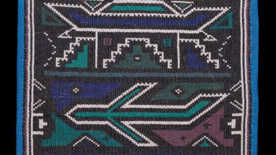 Beaded square textile with geometric patterns in black, teal, purple, and white, bordered with blue and black beads. [gen-ai]