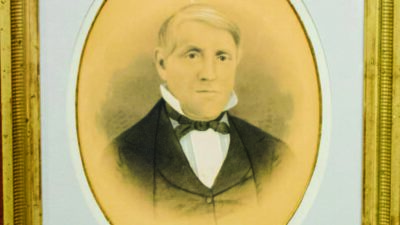 Portrait of a middle-aged man in formal 19th-century attire, with light hair, pictured in an oval frame with a gold border. [gen-ai]