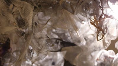 Close-up of light shining through layers of translucent mesh fabric, creating abstract shapes and shadows. [gen-ai]