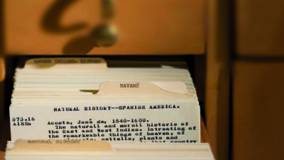 A close-up of a library card catalog drawer labeled Navaho, containing typed index cards about natural history in Spanish America. [gen-ai]