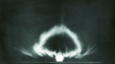 Black and white image of an early-stage nuclear explosion, showing a bright central blast and a developing mushroom-shaped cloud against a dark background. [gen-ai]