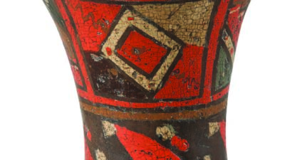 A wooden vessel with a flared rim, decorated with geometric patterns in red, black, and cream colors. [gen-ai]