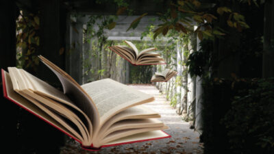 Three open books appear to float in midair along a leafy, pergola-covered pathway with sunlight filtering through the foliage. [gen-ai]