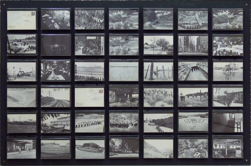 A display board with multiple horizontal rows of black-and-white vintage photographs and postcards, each showing different landscapes, people, buildings, and scenes arranged in a grid layout.
