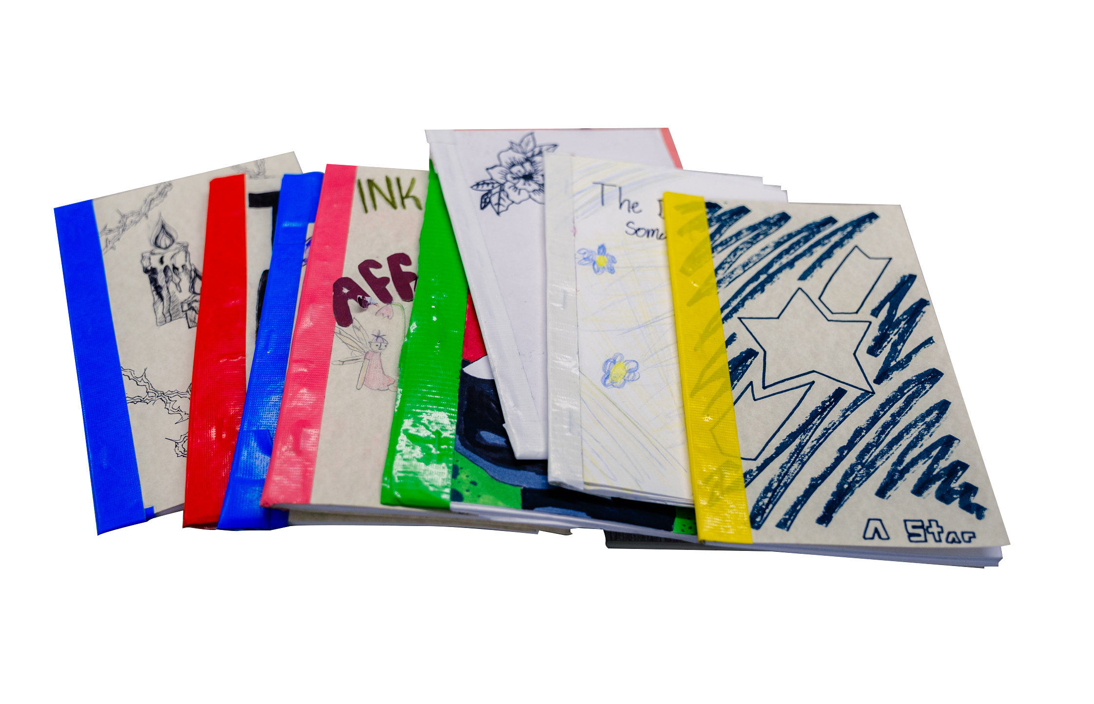 A stack of handmade, colorful booklets with illustrated and decorated covers, featuring drawings, text, and various colors of tape binding the spines, arranged on a white background.
